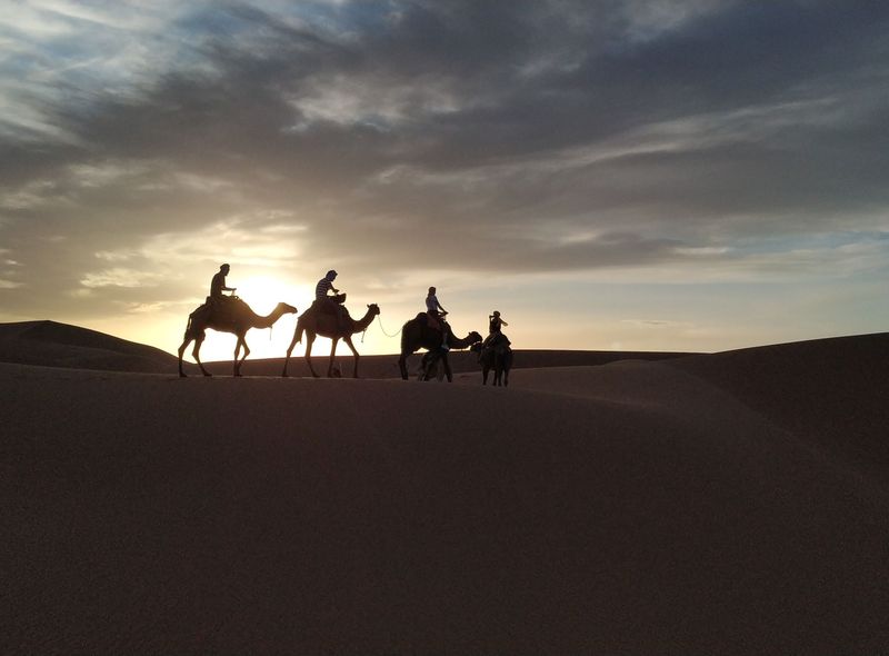 Marokko woestijn op een dromedaris bij zonsondergang