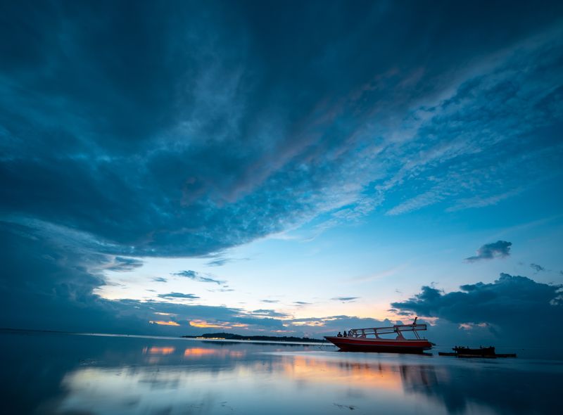 Bali Beach - https://www.pexels.com/nl-nl/foto/foto-van-boot-op-kalm-waterlichaam-onder-blauwe-hemel-2499751/