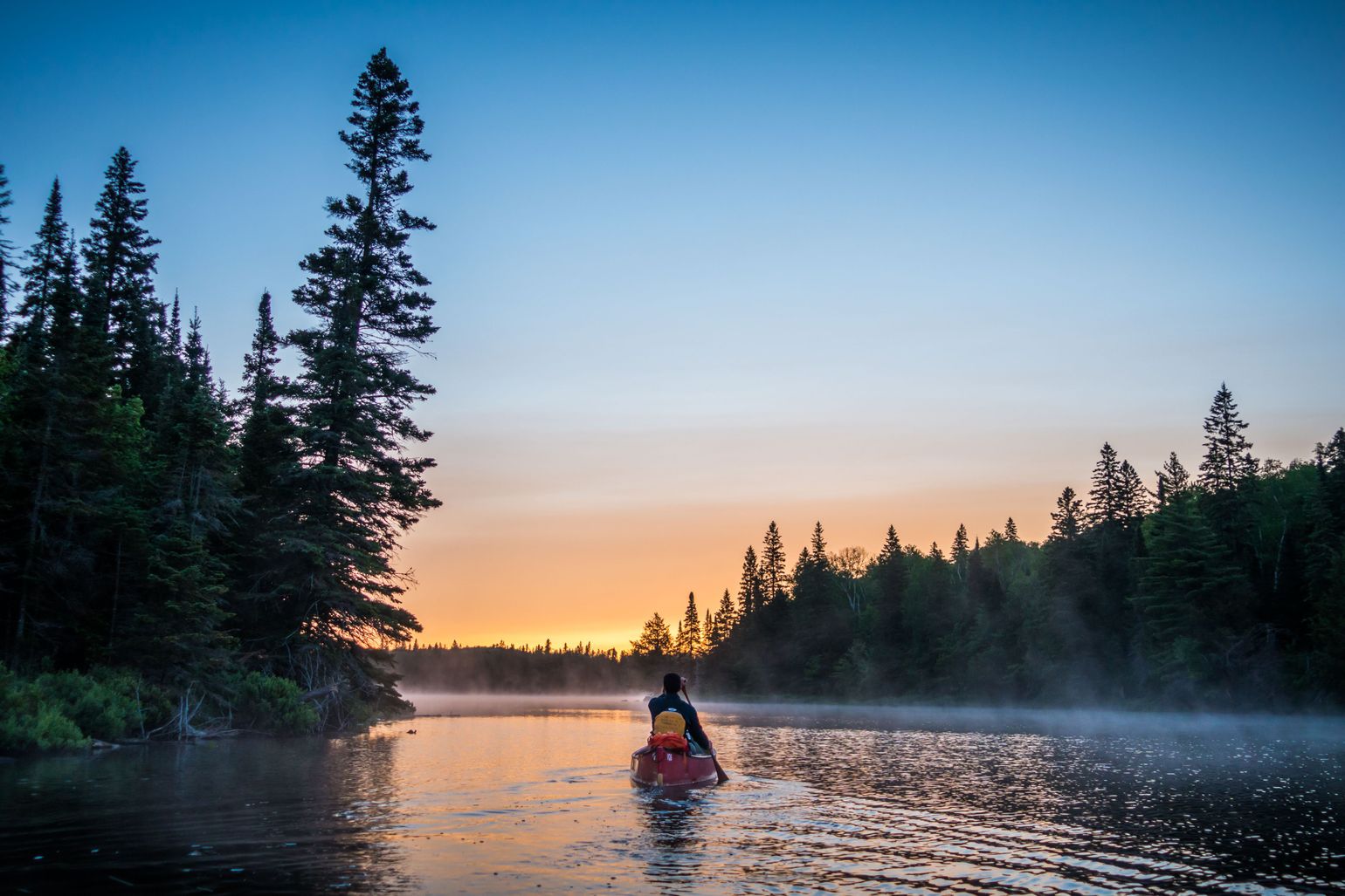 Kanoër bij zonsopkomst